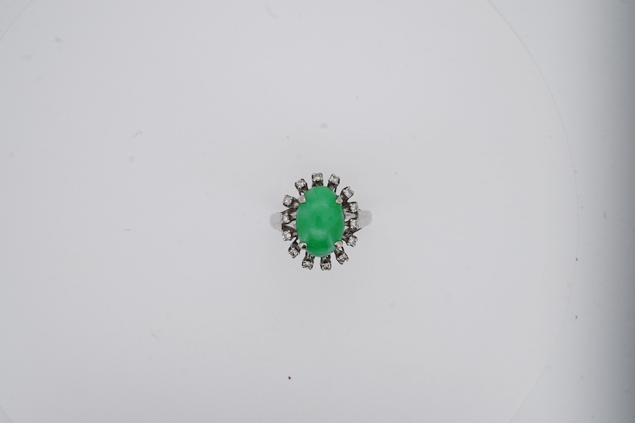 A white metal and cabochon jade set ring, with round cut diamond set border, size N, gross weight 5.4 grams. Condition - fair to good